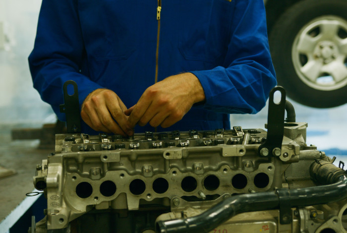 mécanicien qui ajuste piston moteur 